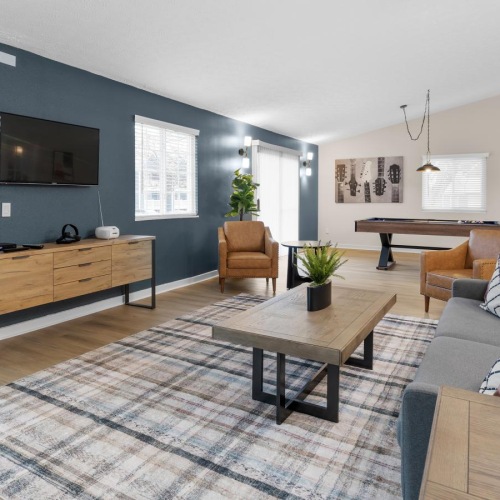 a clubroom with a tv, couch and chairs